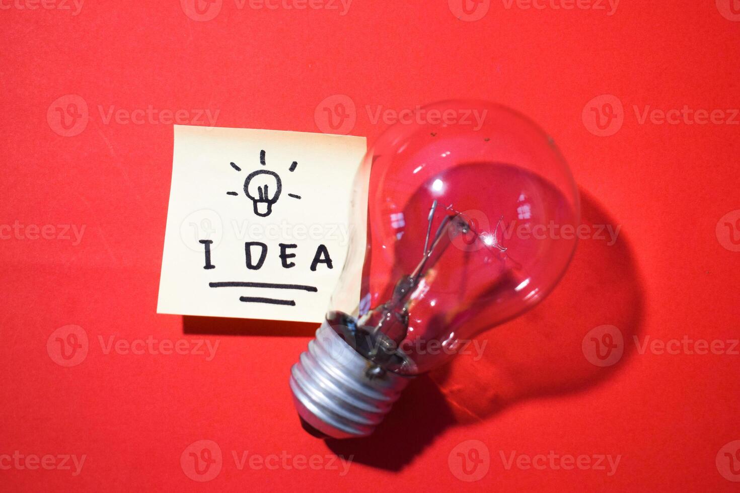 Idea on sticky notes and lightbulb. Isolated red background and copy space photo