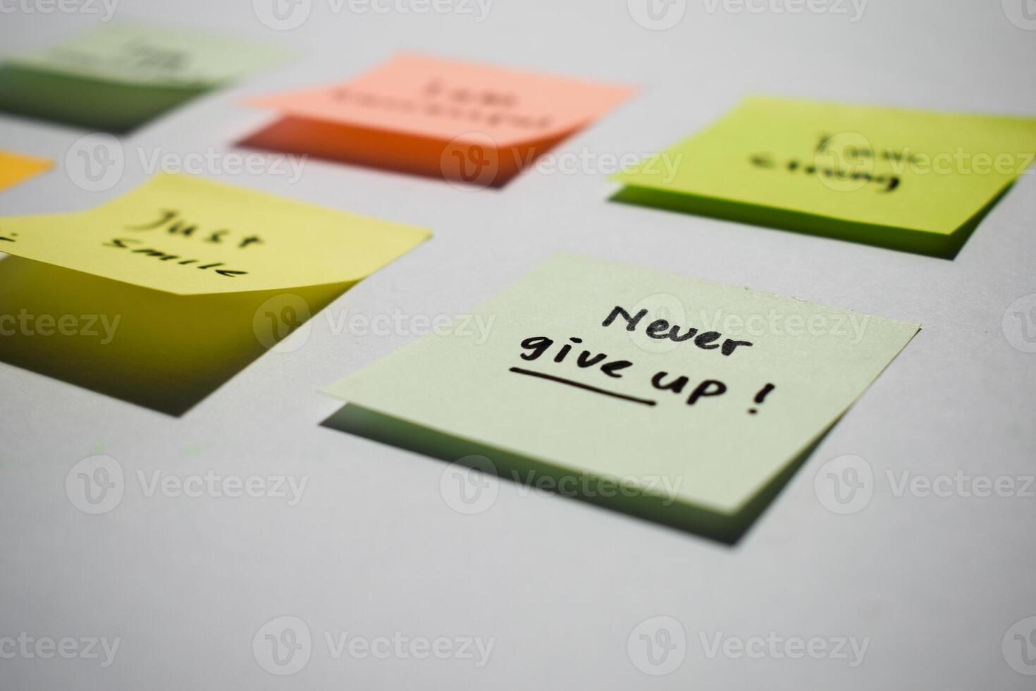 Never give up on sticky notes. Motivational words for personal development, inspirational handwriting. Isolated background photo