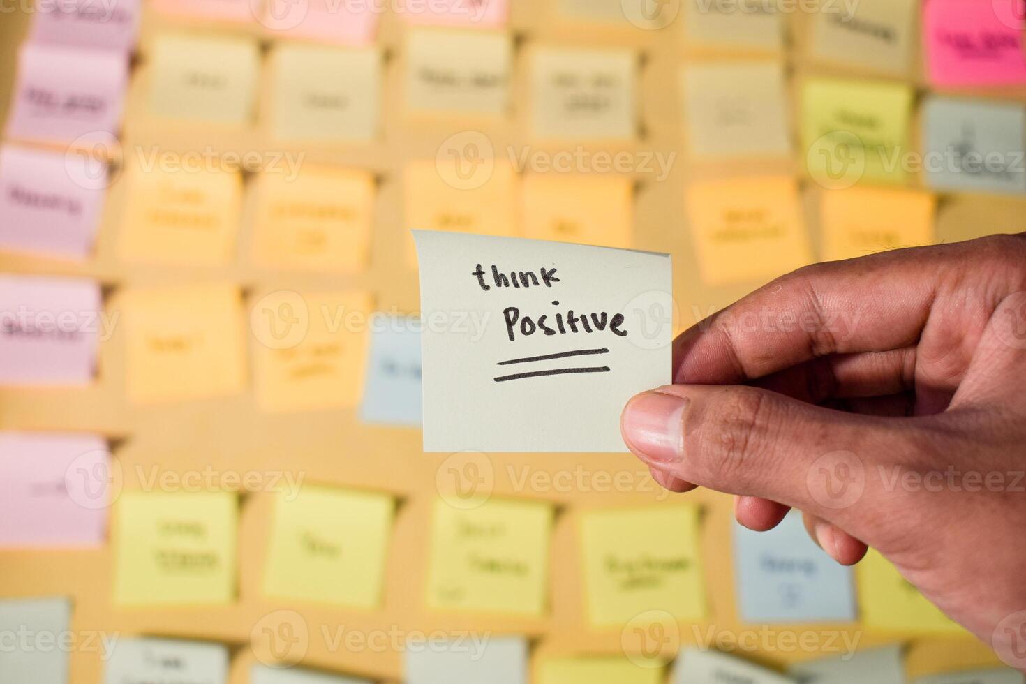 Hand hold sticky notes with words Think Positive. Motivational words for personal development, inspirational handwriting. Sticky notes background photo