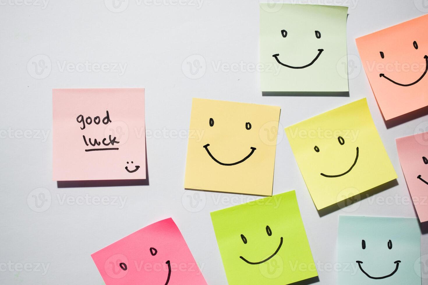 Good Luck and smile emoticon on sticky notes. Motivational words for personal development, inspirational handwriting. Isolated on background photo