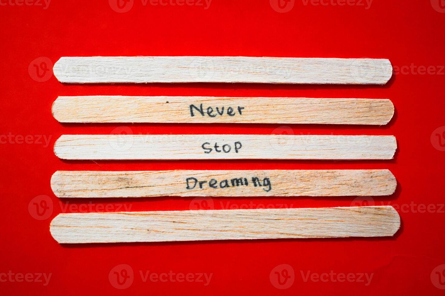 stick of ice cream with the words Never Stop Dreaming. Motivational quotes, optimism, positive words. Isolated on background photo