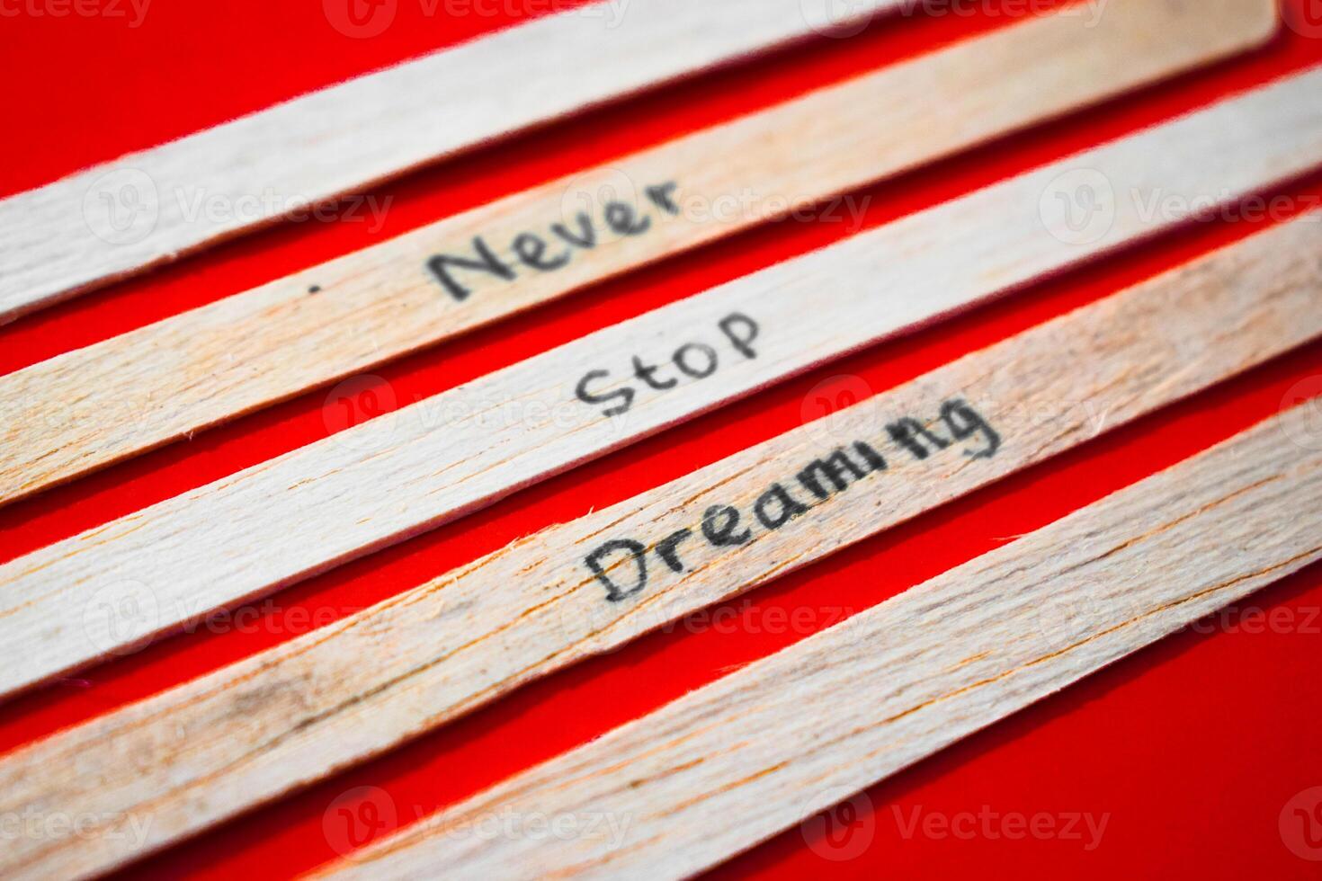 stick of ice cream with the words Never Stop Dreaming. Motivational quotes, optimism, positive words. Isolated on background photo