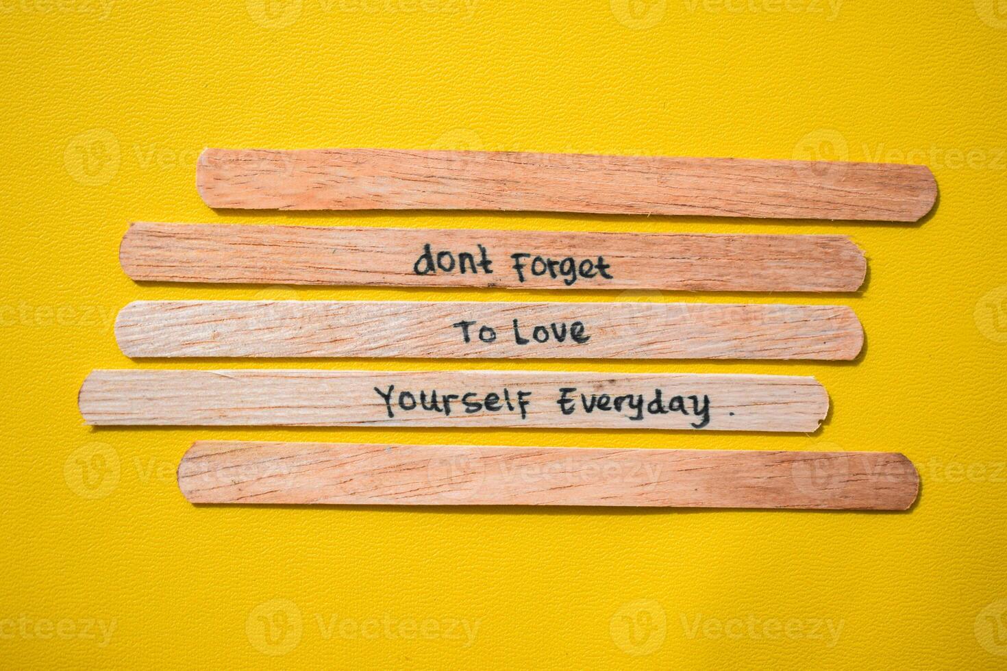 stick of ice cream with the words don't forget to love yourself everyday. Motivational quotes, optimism, positive words. Isolated on background photo