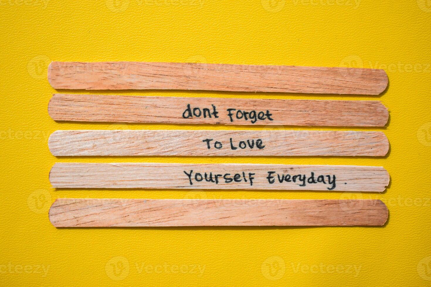 stick of ice cream with the words don't forget to love yourself everyday. Motivational quotes, optimism, positive words. Isolated on background photo