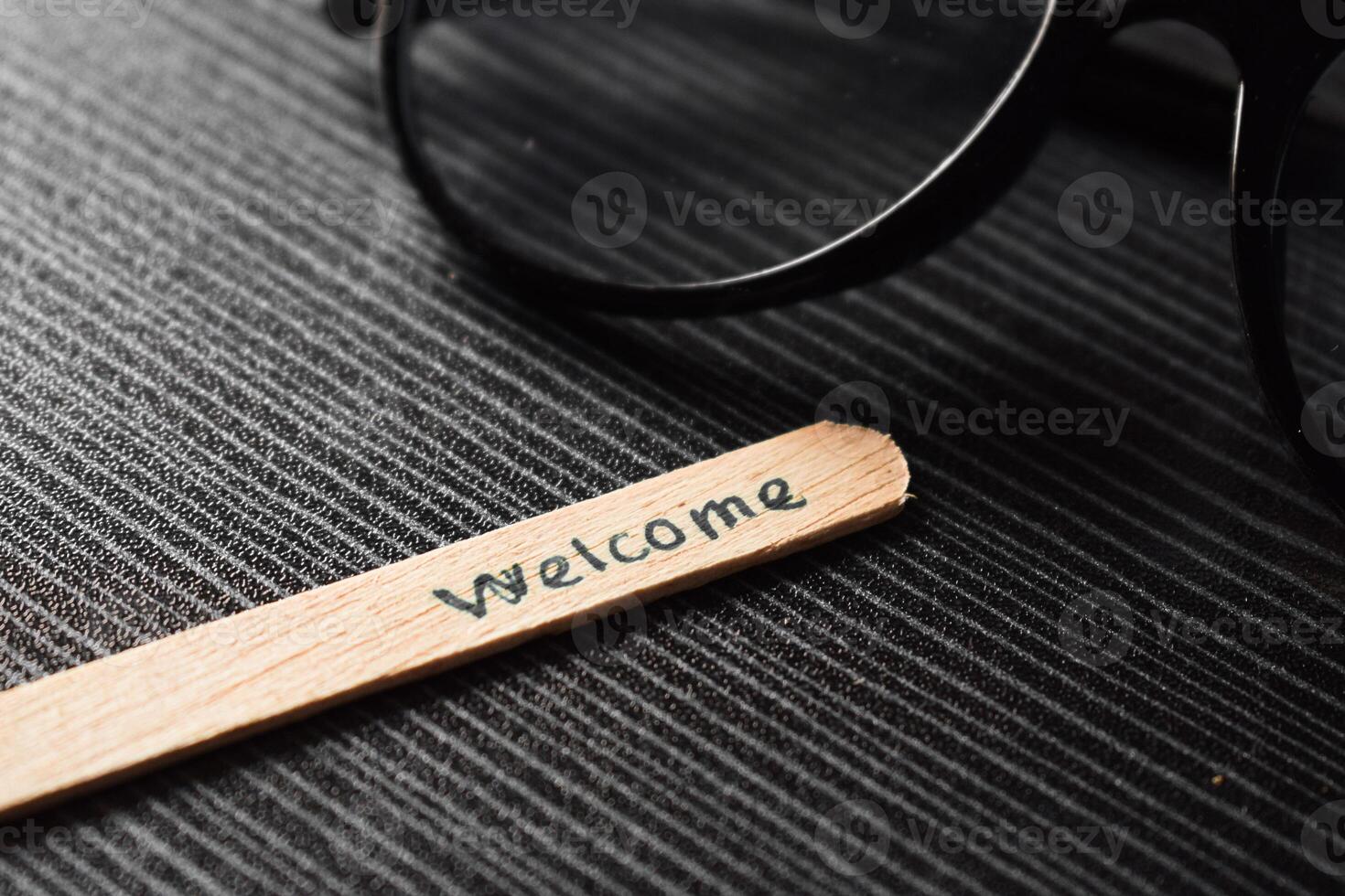 stick of ice cream with the words welcome and the eyeglasses. Motivational quotes, optimism, positive words on the table photo