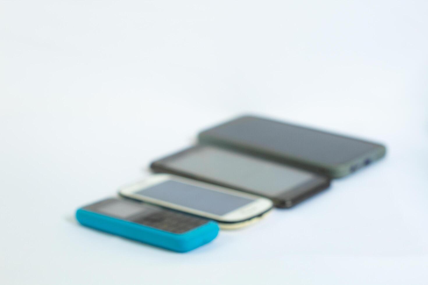 The phones are neatly arranged in a row and photographed blurry from a side angle photo