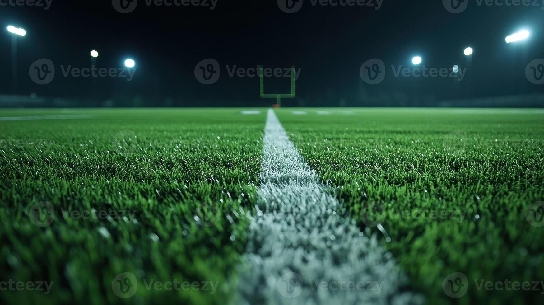 Football Field at Night with Illuminated Goalposts and Fresh Green Turf Under Stadium Lights photo