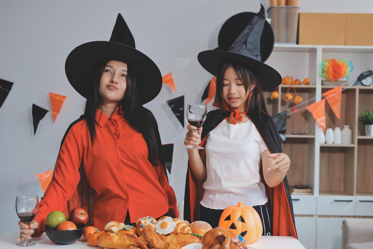 friendship, holiday and people concept - group of happy smiling friends in halloween costumes of vampire, devil, witch and cheetah at home party photo