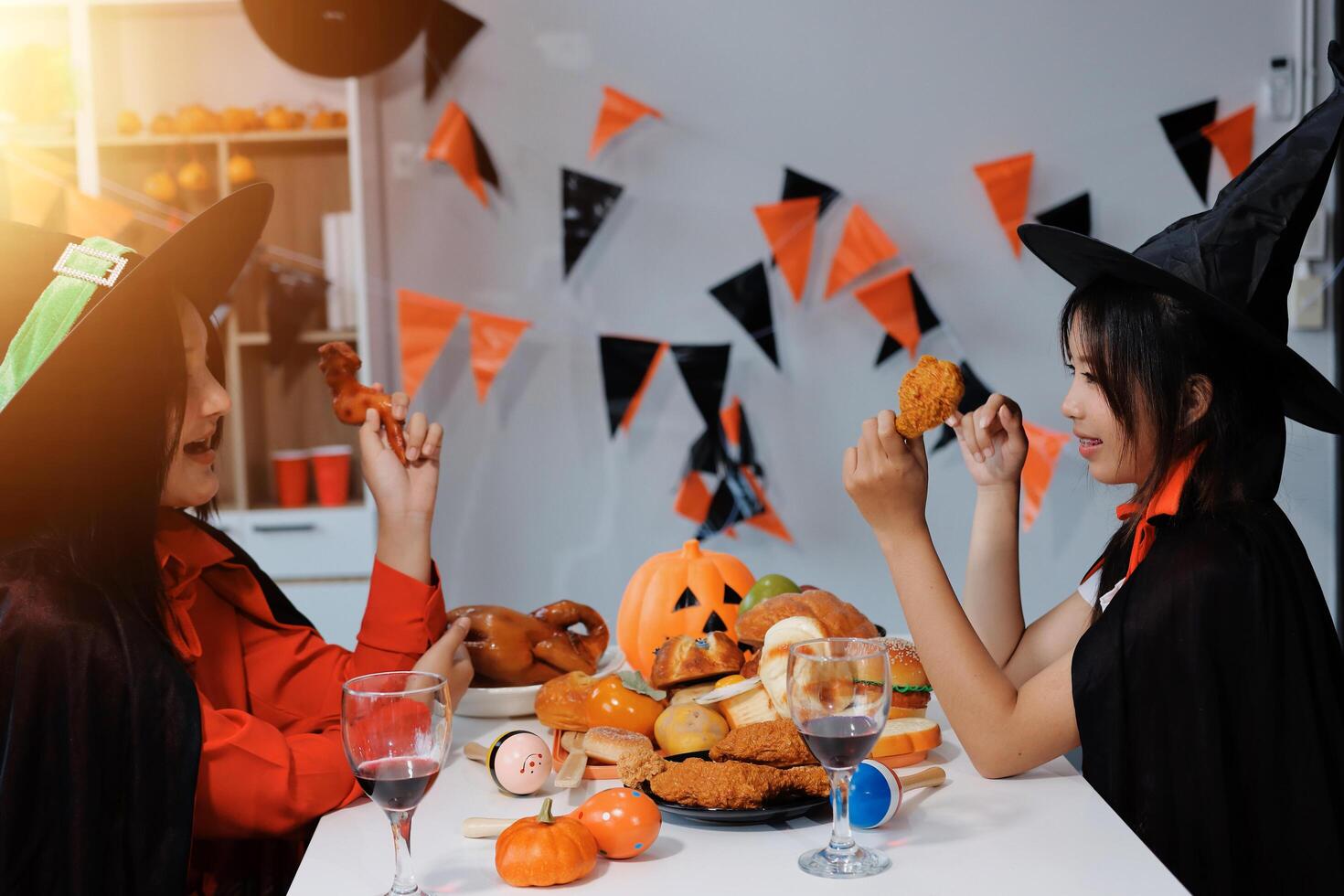 friendship, holiday and people concept - group of happy smiling friends in halloween costumes of vampire, devil, witch and cheetah at home party photo