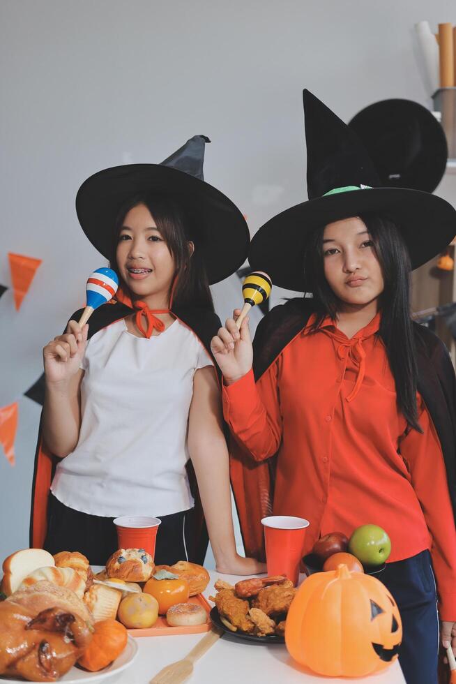 friendship, holiday and people concept - group of happy smiling friends in halloween costumes of vampire, devil, witch and cheetah at home party photo