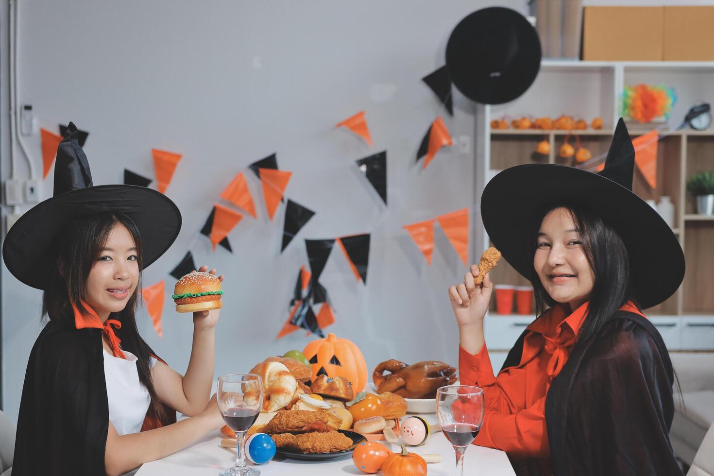 friendship, holiday and people concept - group of happy smiling friends in halloween costumes of vampire, devil, witch and cheetah at home party photo