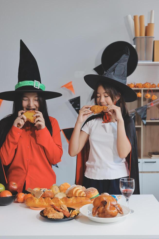 friendship, holiday and people concept - group of happy smiling friends in halloween costumes of vampire, devil, witch and cheetah at home party photo