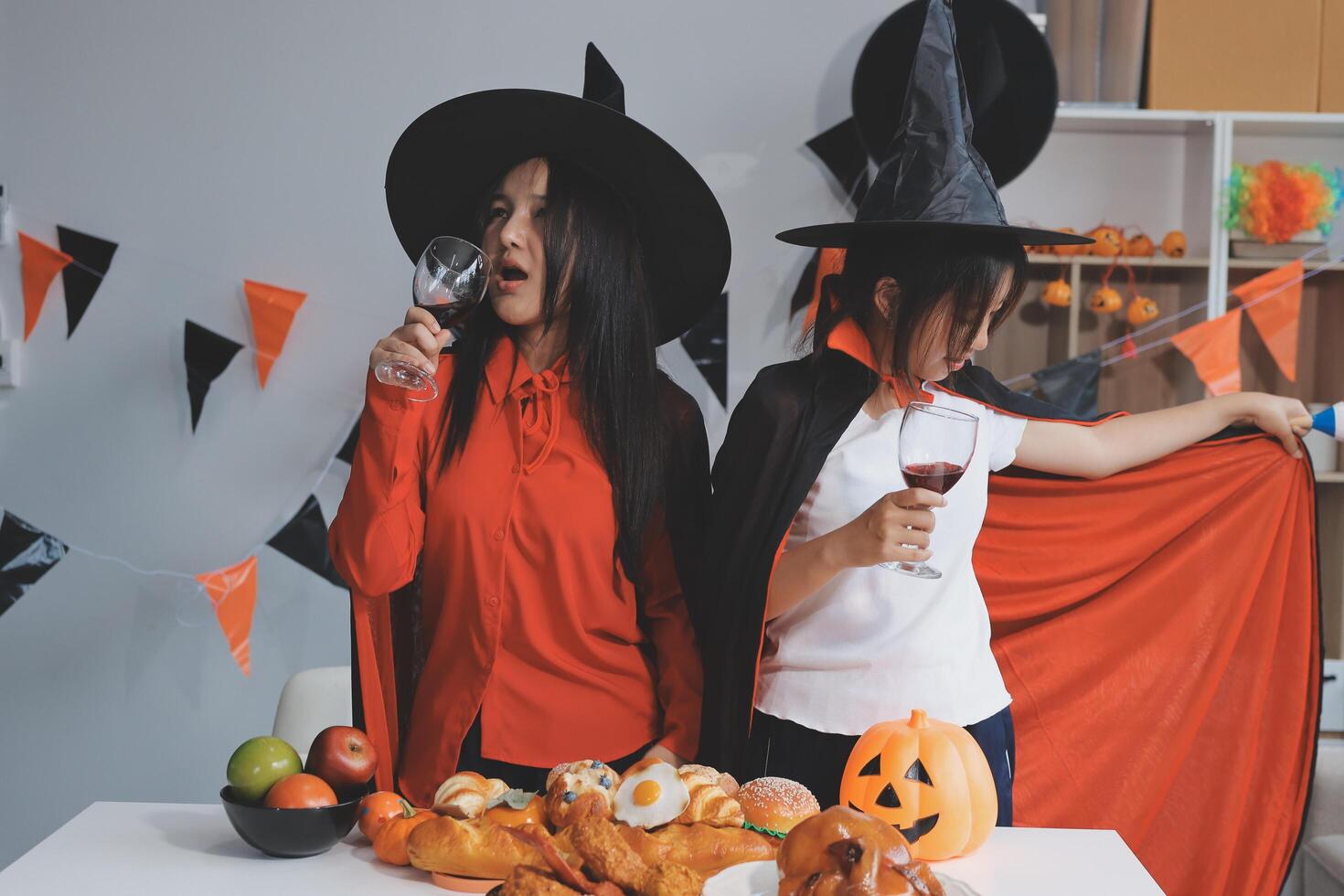 friendship, holiday and people concept - group of happy smiling friends in halloween costumes of vampire, devil, witch and cheetah at home party photo