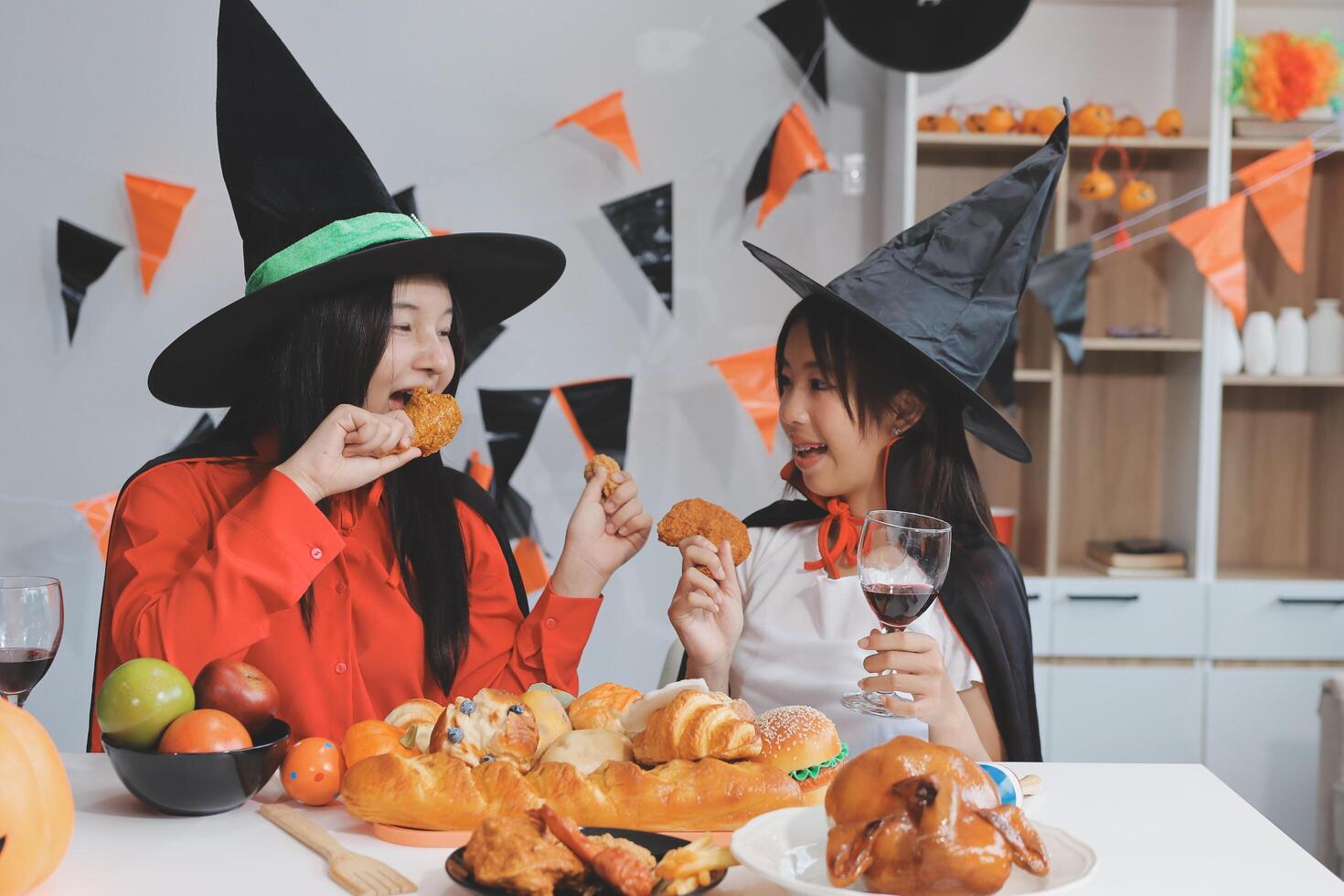 friendship, holiday and people concept - group of happy smiling friends in halloween costumes of vampire, devil, witch and cheetah at home party photo