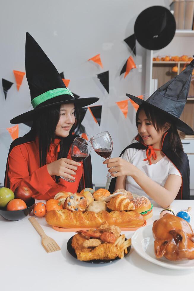 friendship, holiday and people concept - group of happy smiling friends in halloween costumes of vampire, devil, witch and cheetah at home party photo