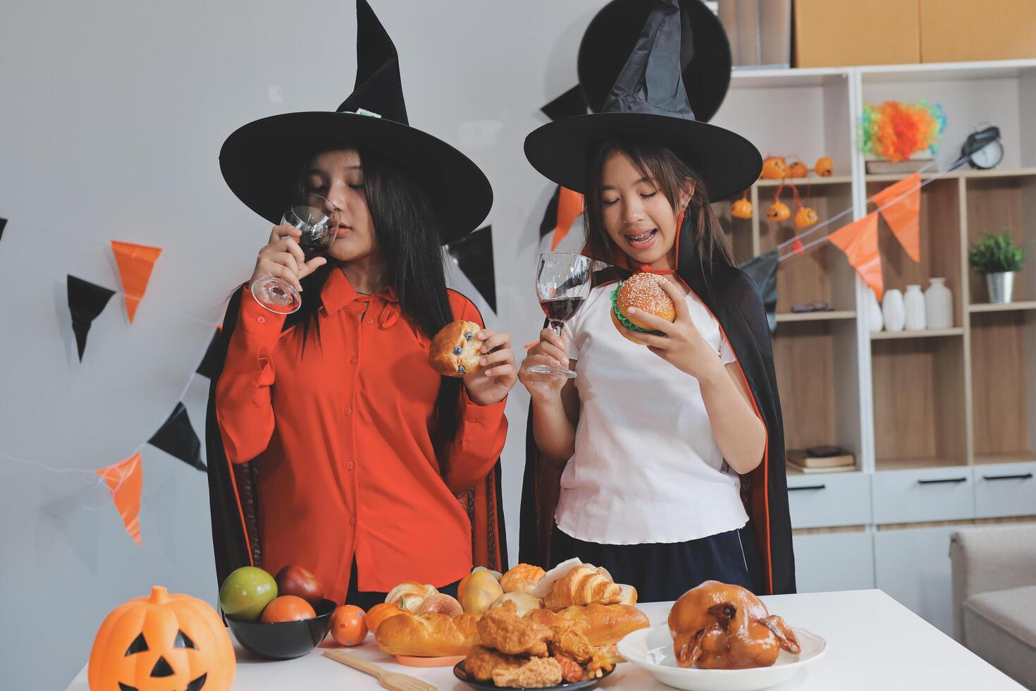friendship, holiday and people concept - group of happy smiling friends in halloween costumes of vampire, devil, witch and cheetah at home party photo
