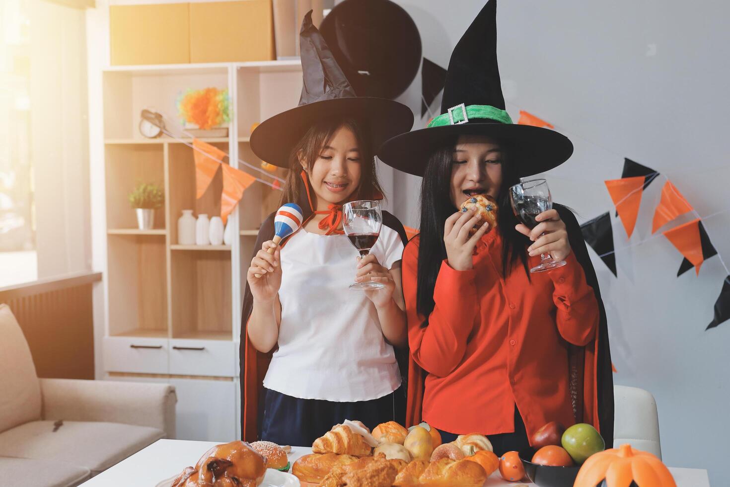 friendship, holiday and people concept - group of happy smiling friends in halloween costumes of vampire, devil, witch and cheetah at home party photo