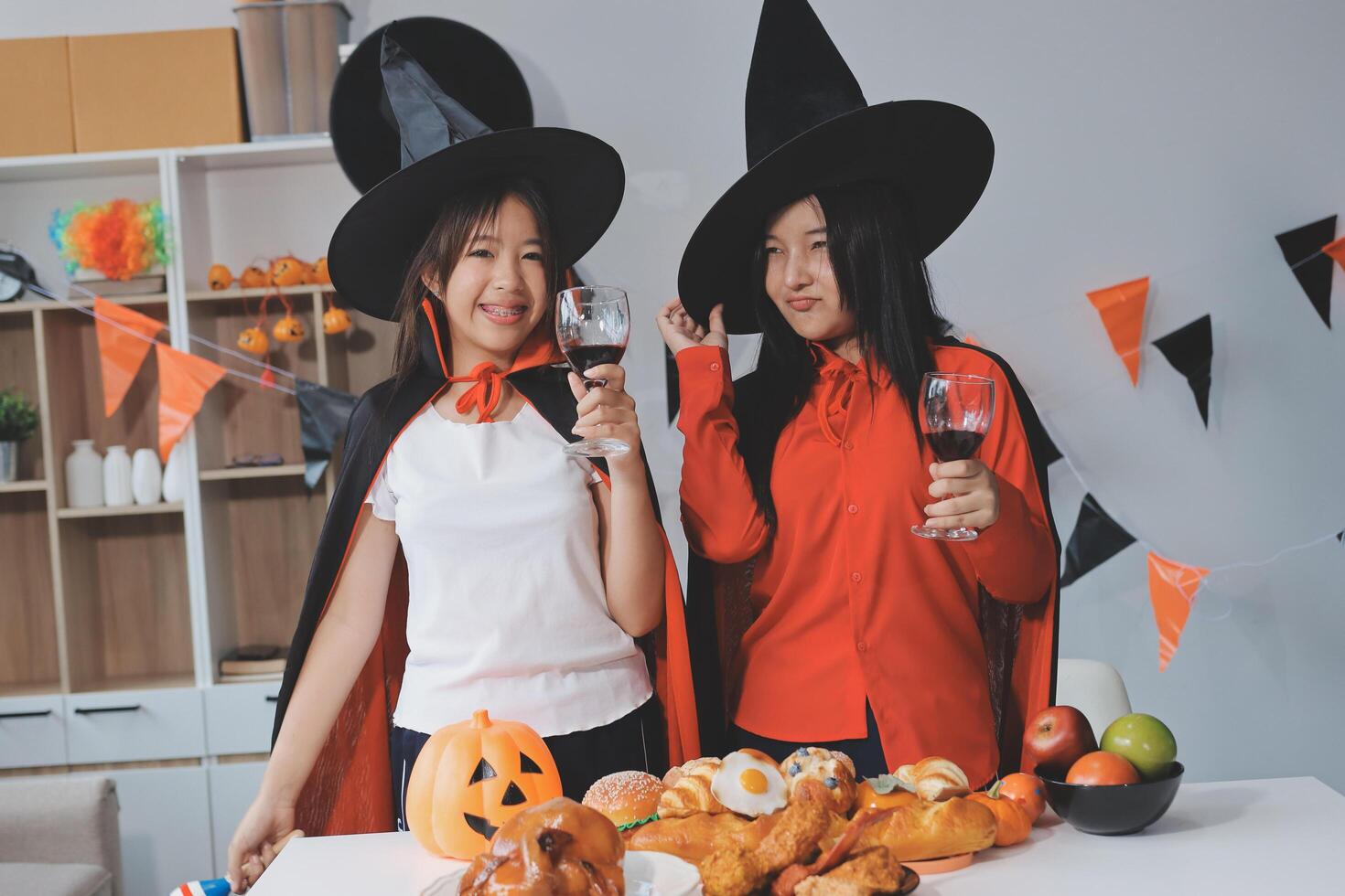 friendship, holiday and people concept - group of happy smiling friends in halloween costumes of vampire, devil, witch and cheetah at home party photo