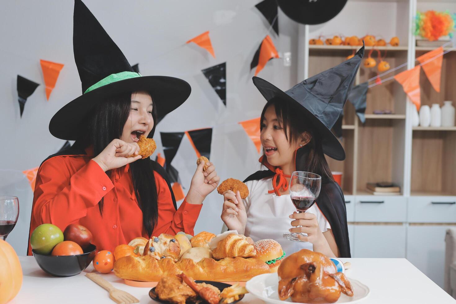 friendship, holiday and people concept - group of happy smiling friends in halloween costumes of vampire, devil, witch and cheetah at home party photo