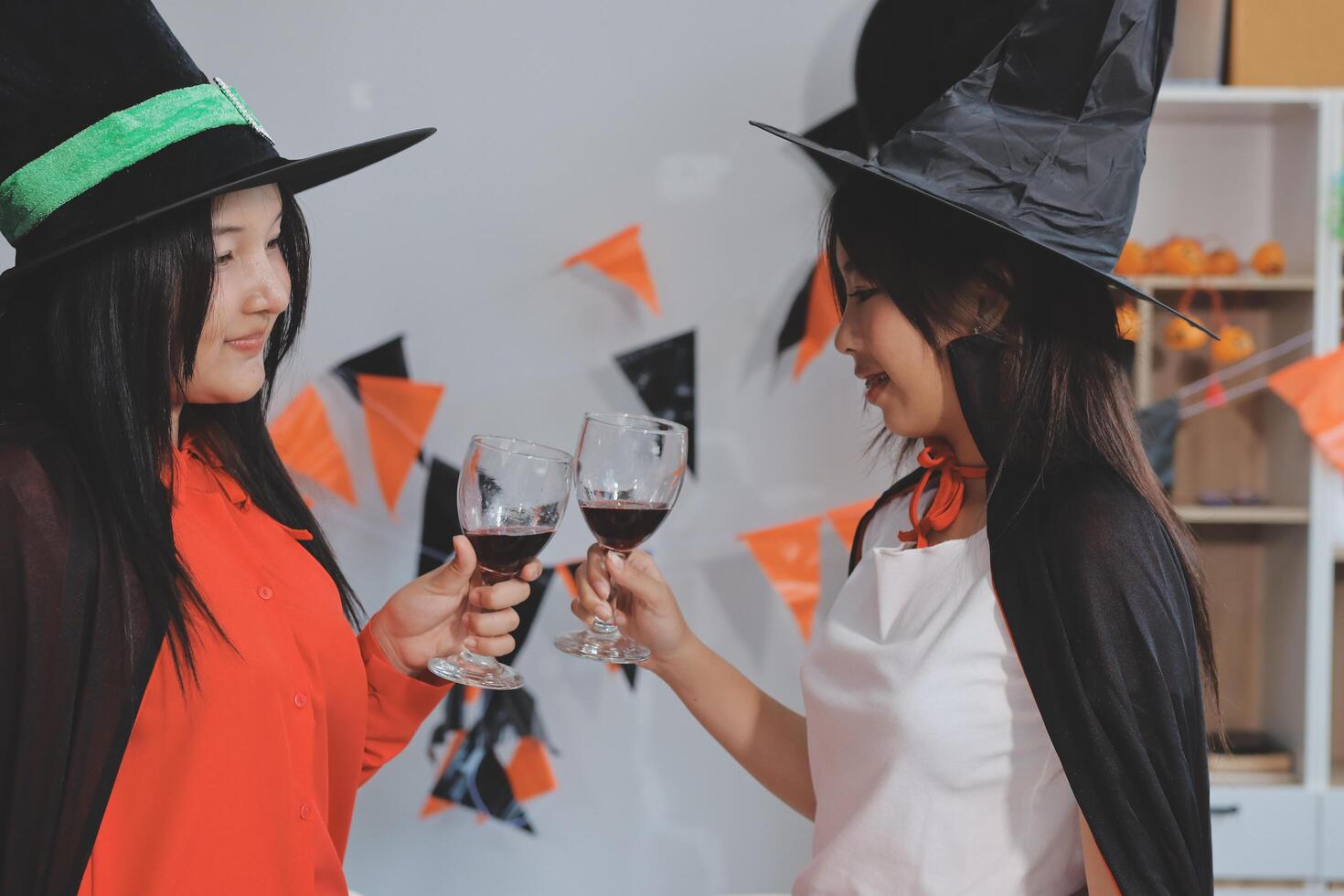 friendship, holiday and people concept - group of happy smiling friends in halloween costumes of vampire, devil, witch and cheetah at home party photo