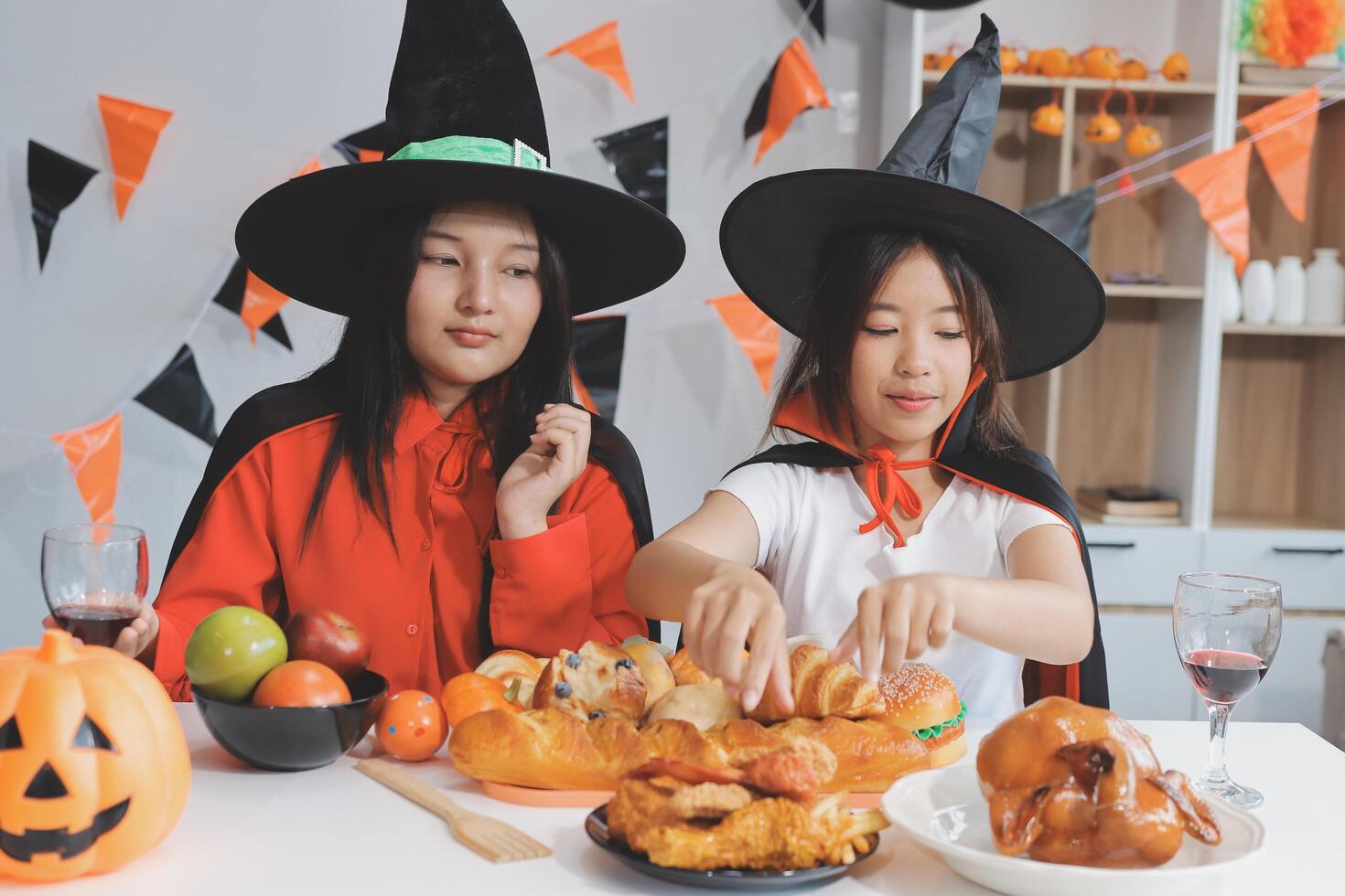 friendship, holiday and people concept - group of happy smiling friends in halloween costumes of vampire, devil, witch and cheetah at home party photo