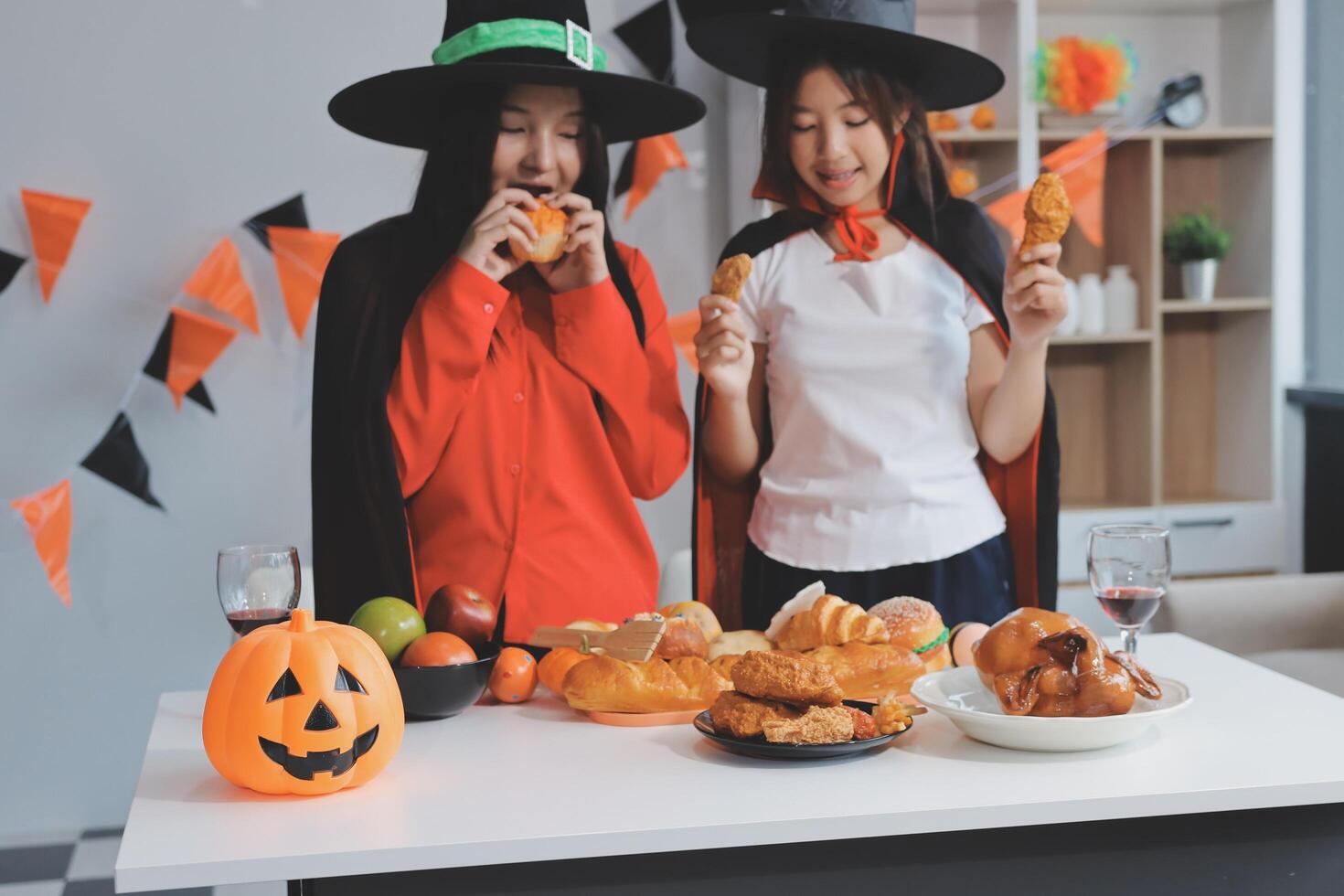 friendship, holiday and people concept - group of happy smiling friends in halloween costumes of vampire, devil, witch and cheetah at home party photo