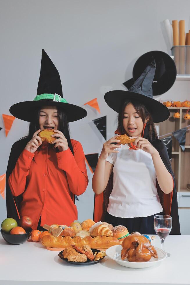 friendship, holiday and people concept - group of happy smiling friends in halloween costumes of vampire, devil, witch and cheetah at home party photo