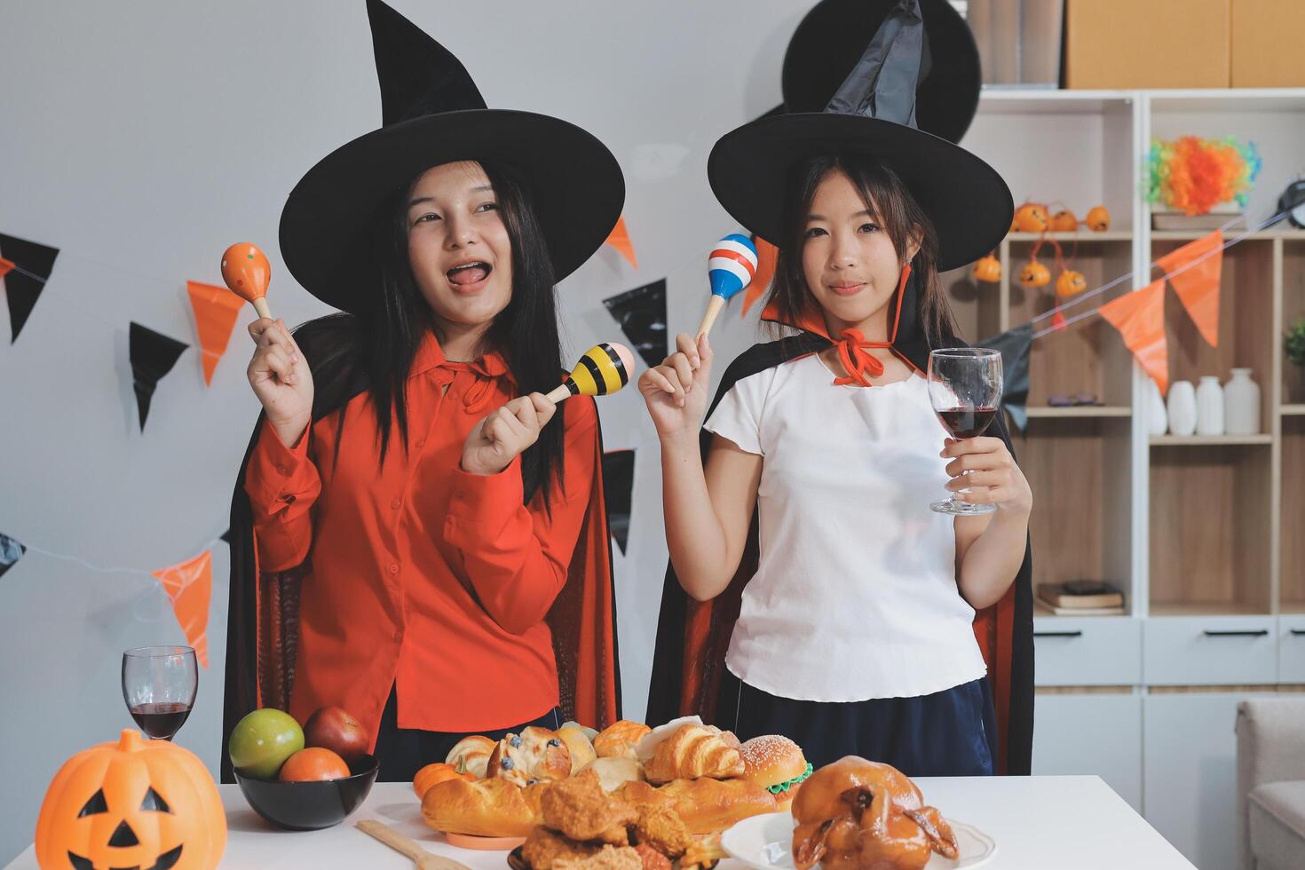 friendship, holiday and people concept - group of happy smiling friends in halloween costumes of vampire, devil, witch and cheetah at home party photo