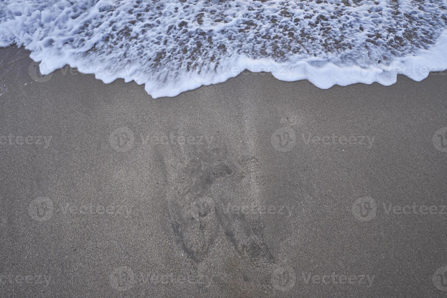 Sandy beach with small waves, an abstract background photo