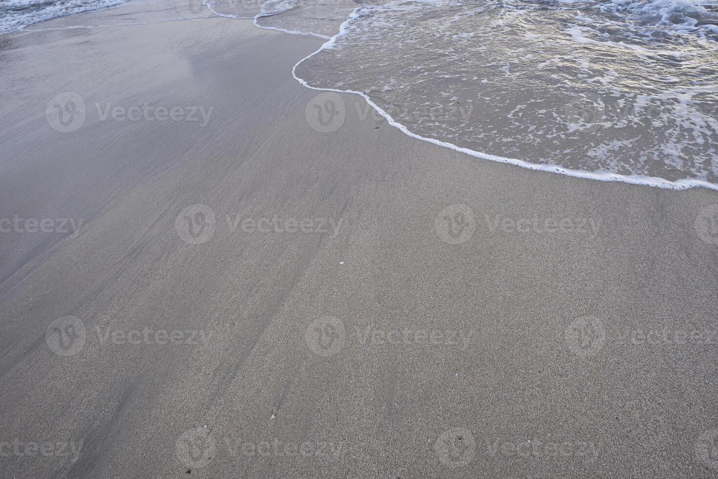 Small waves on sandy beach, abstract background photo