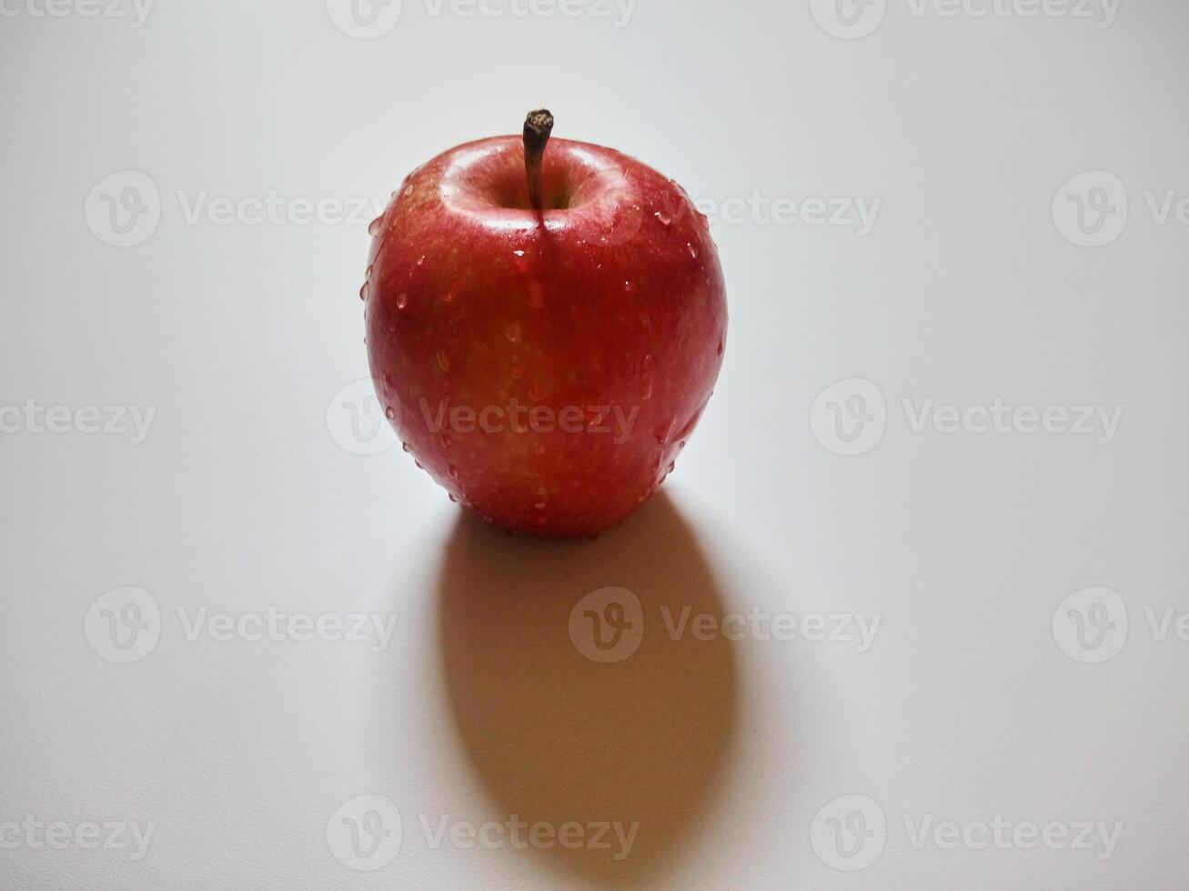 Single red apple with water drops isolated on white background. Close up view of natural fruits photo concept.