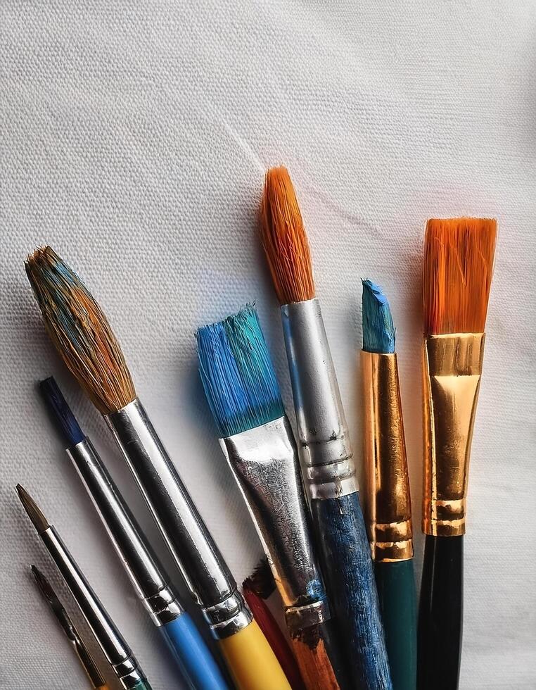 Paint and brushes lie on a white canvas. Creative Activities photo