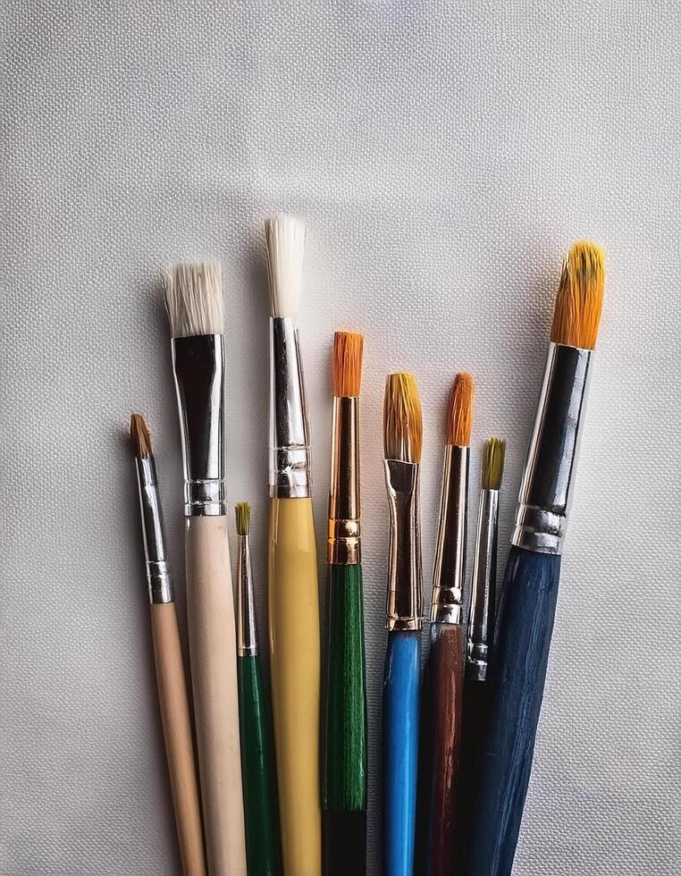 Paint and brushes lie on a white canvas. Creative Activities photo