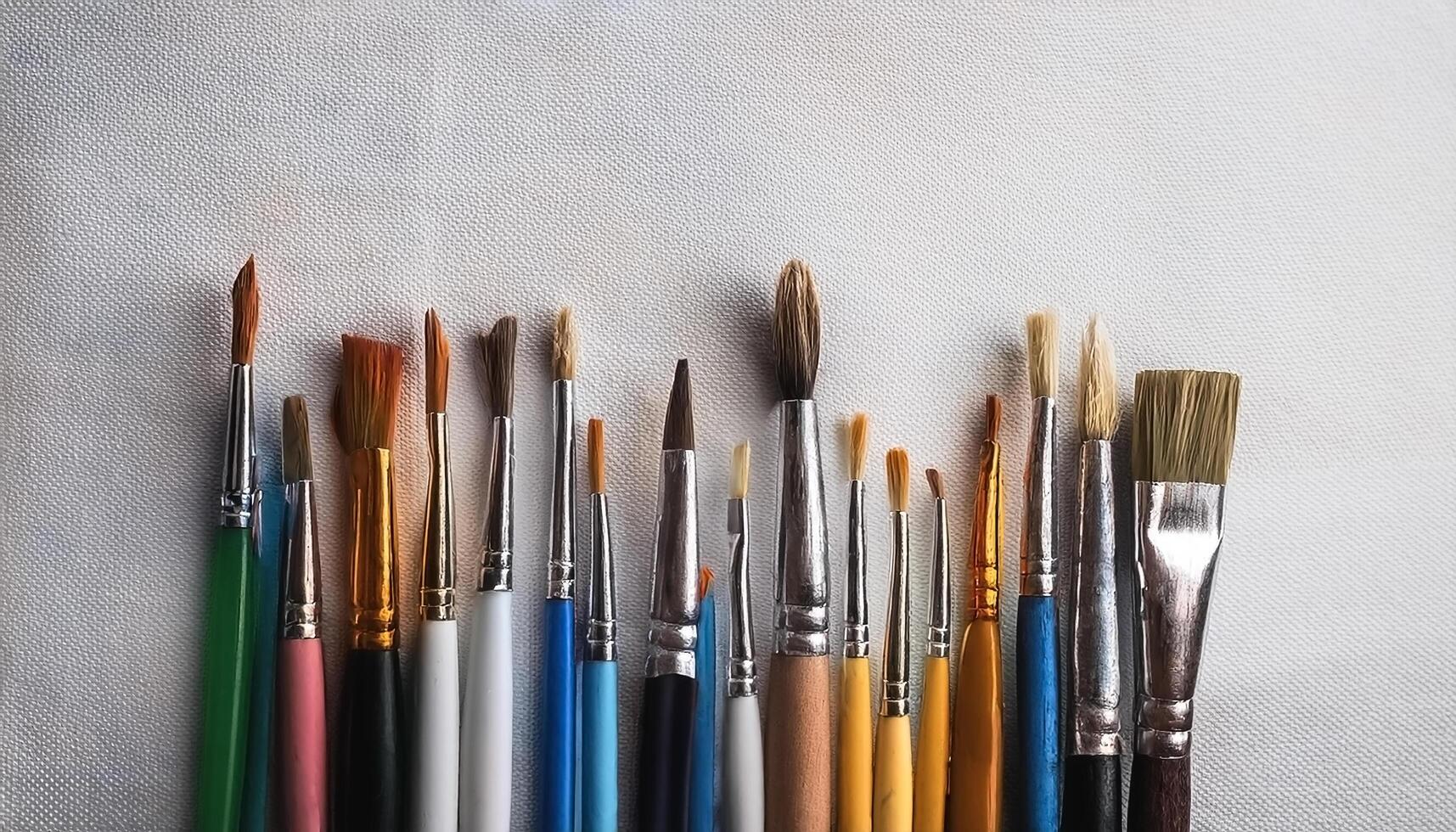 Paint and brushes lie on a white canvas. Creative Activities photo