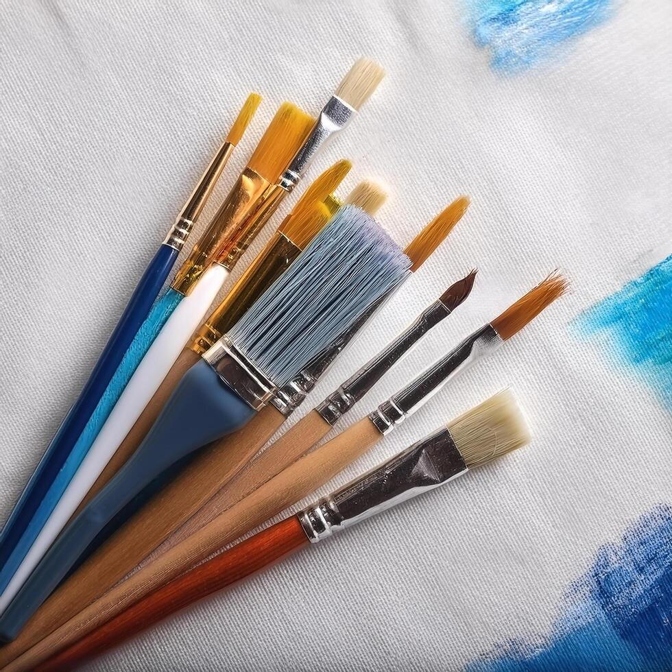 Paint and brushes lie on a white canvas. Creative Activities photo