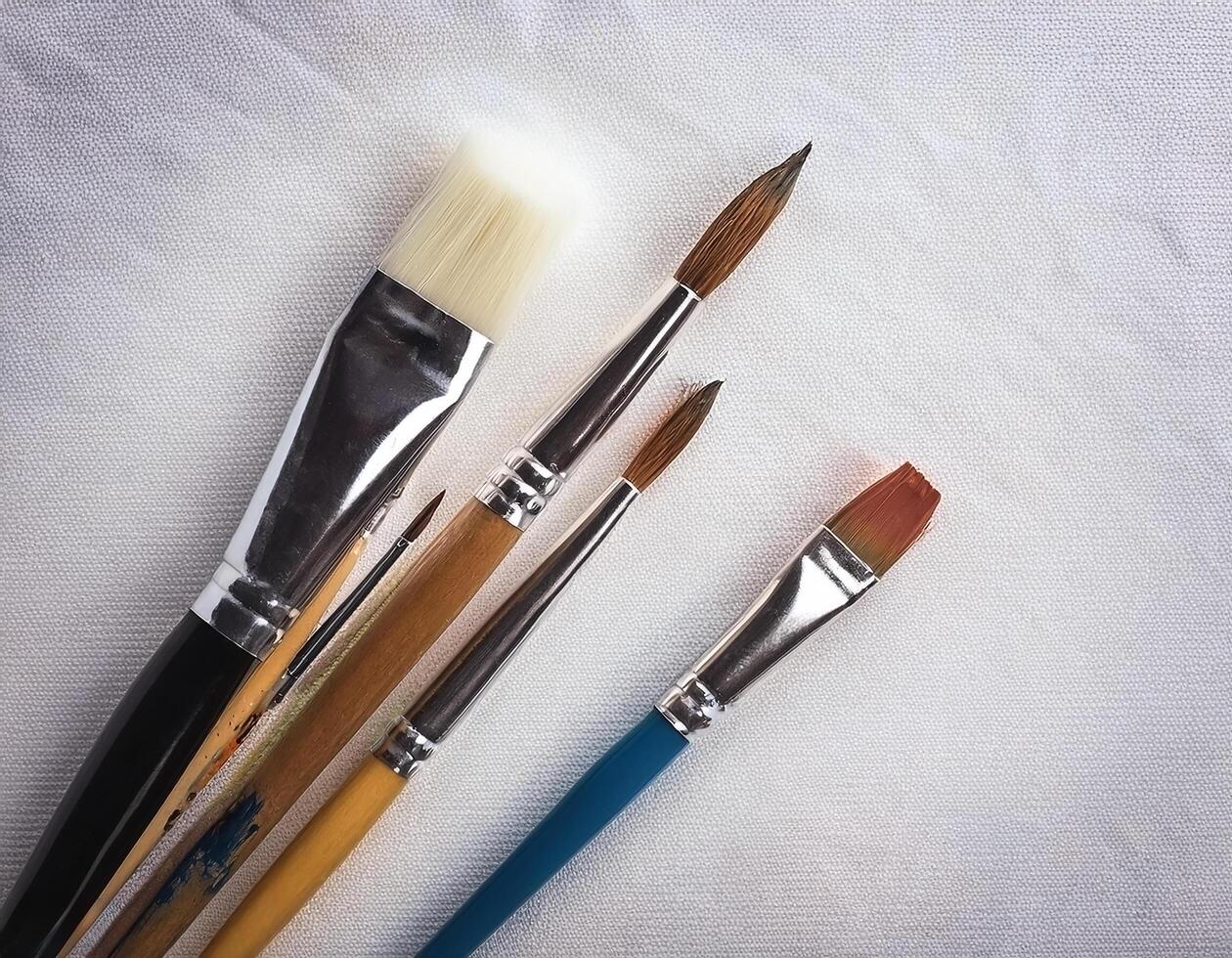 Paint and brushes lie on a white canvas. Creative Activities photo