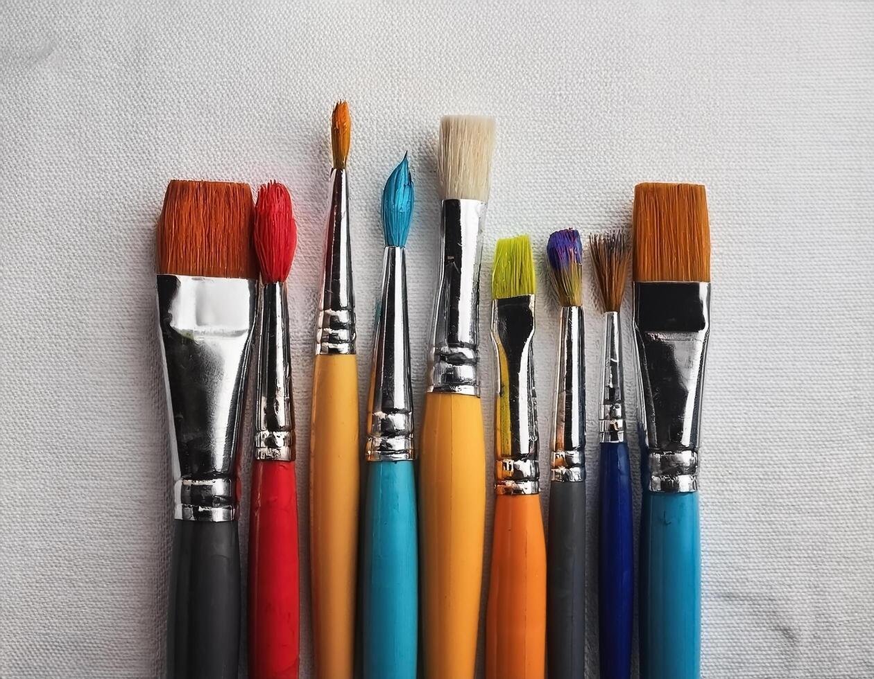 Paint and brushes lie on a white canvas. Creative Activities photo