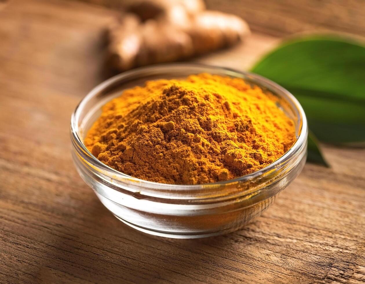 Turmeric spice in a glass container, on a natural wooden background photo