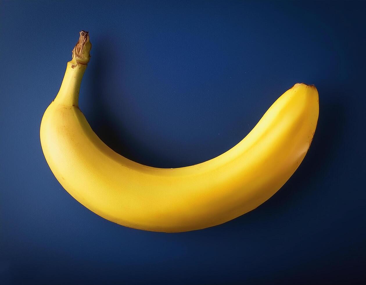 Yellow banana isolated on navy blue background photo