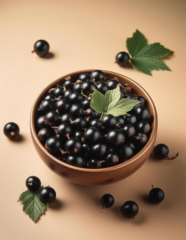 Black currants in a bowl, surrounded on a beige background photo