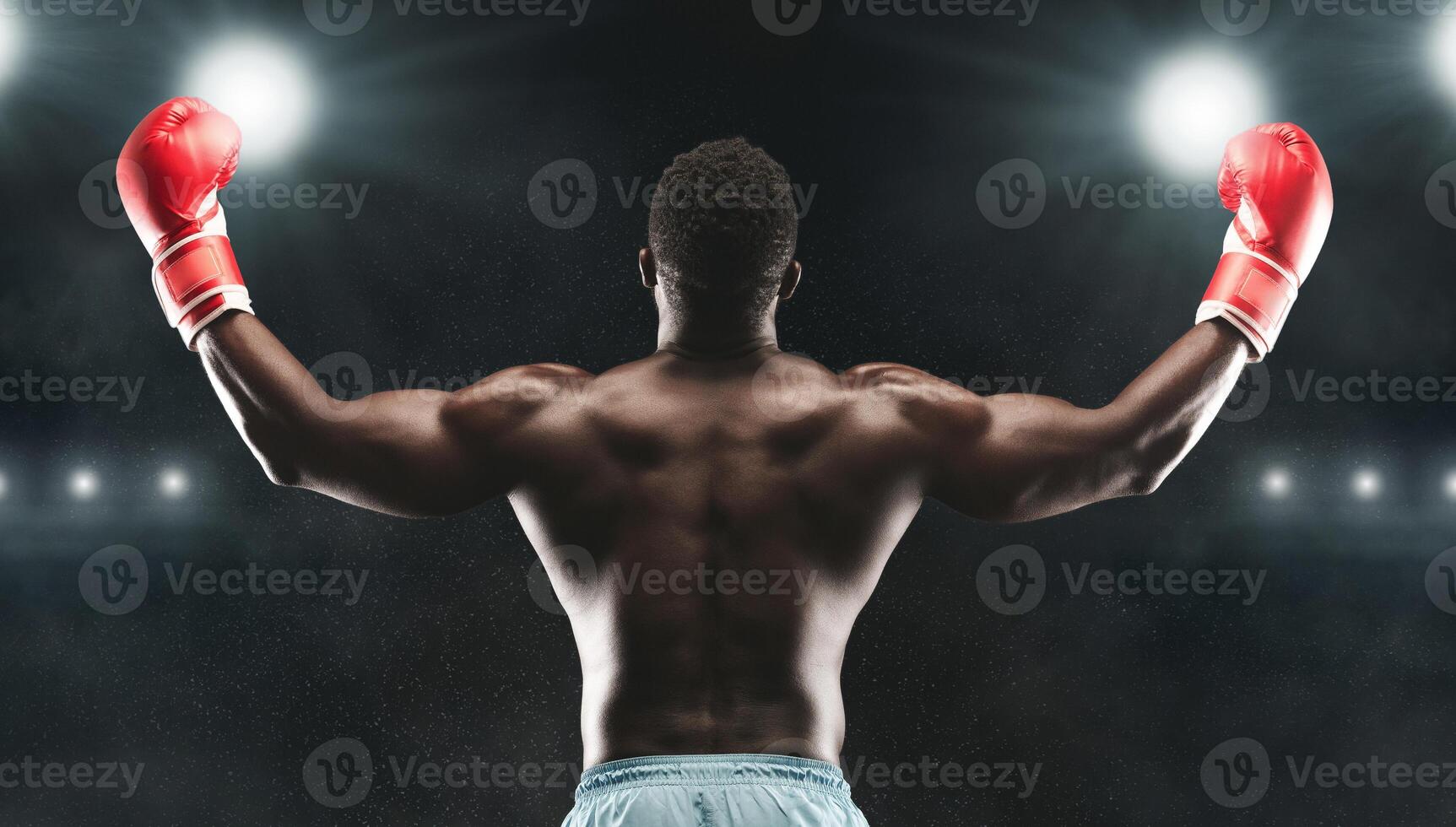 Champion. African boxer raising his arms in winner gesture, stadium lights background, back view photo