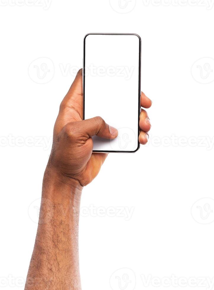 Mockup image of black man's hand holding smartphone with blank screen isolated on white background, copy space photo