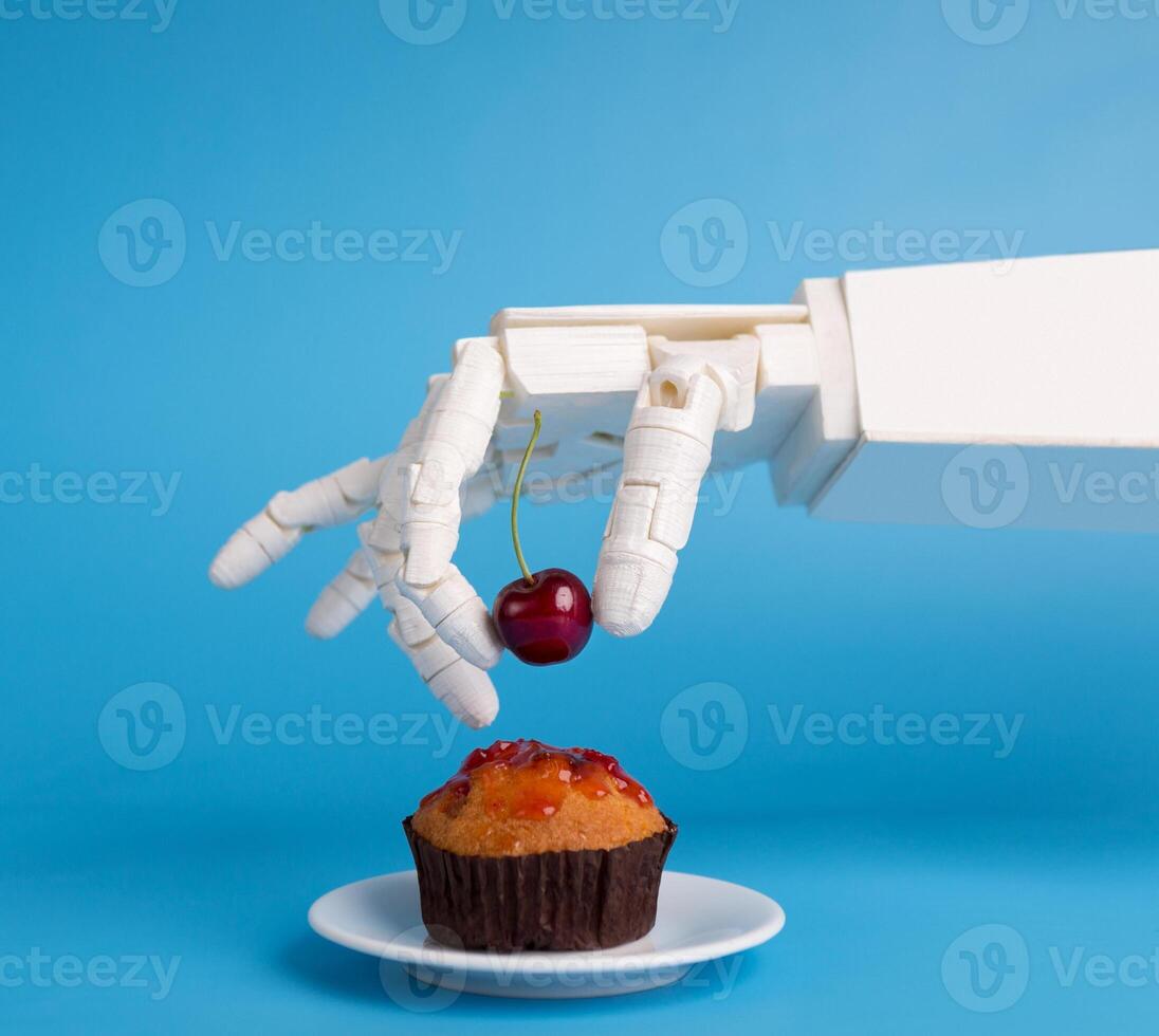 Chef robotic assistant in kitchen technology. Robot hand decorating sweet cupcake with fresh cherry, blue background photo