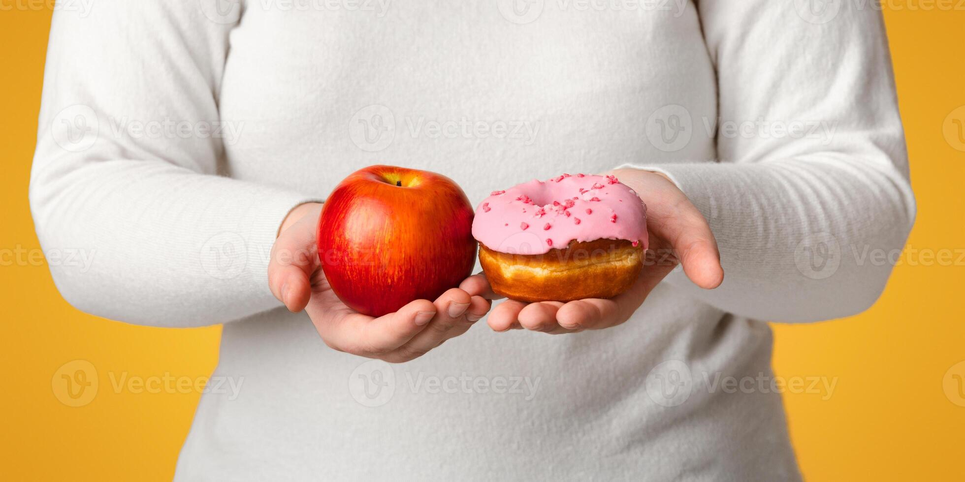 Healthy Vs Unhealthy. Unrecognizable Obese Woman Holding Donut And Apple In Hands, Offering Snacks At Camera, Cropped Image, Panorama photo