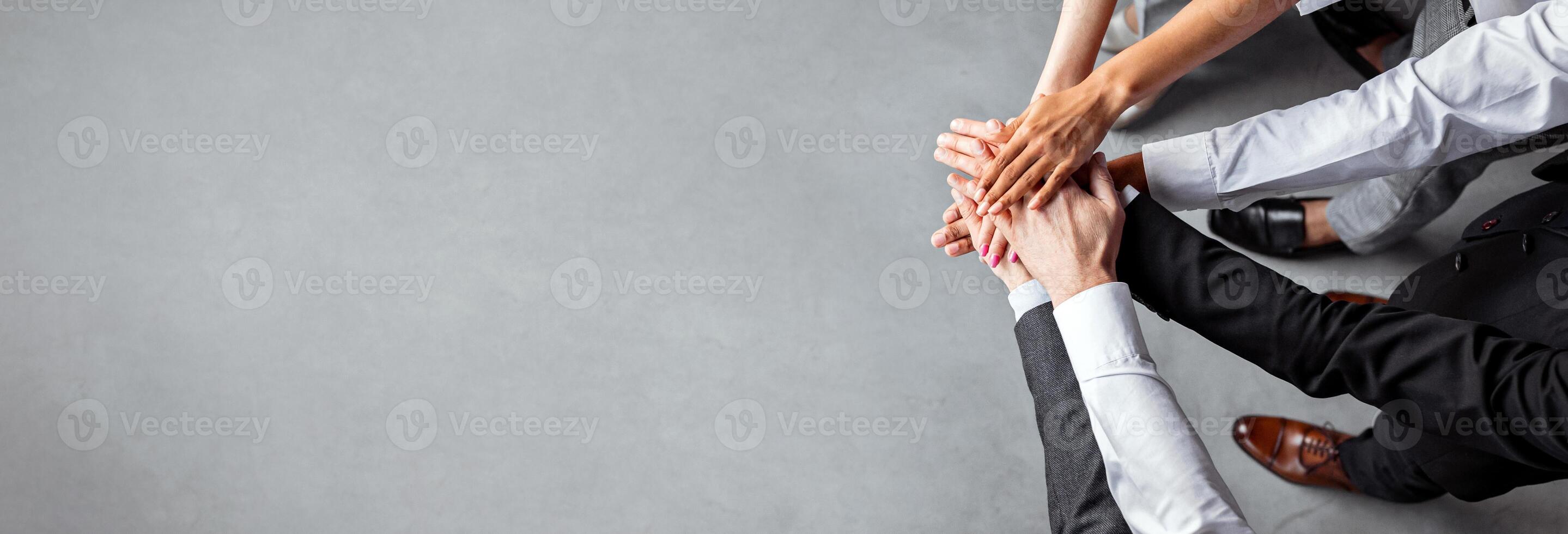 Teambuilding And Unity. Unrecognizable Coworkers Holding Hands Standing In Office. Cropped, Above View, Copy Space photo