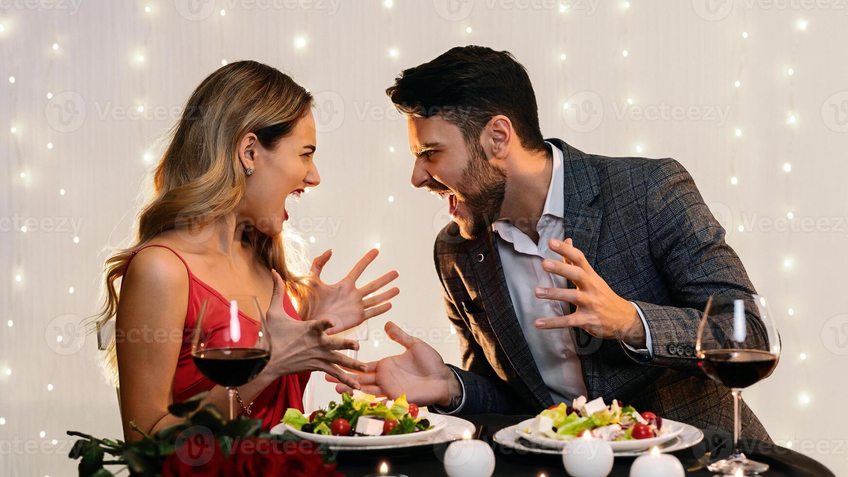 Angry couple arguing during romantic dinner in restaurant, emotionally shouting at each other, free space photo