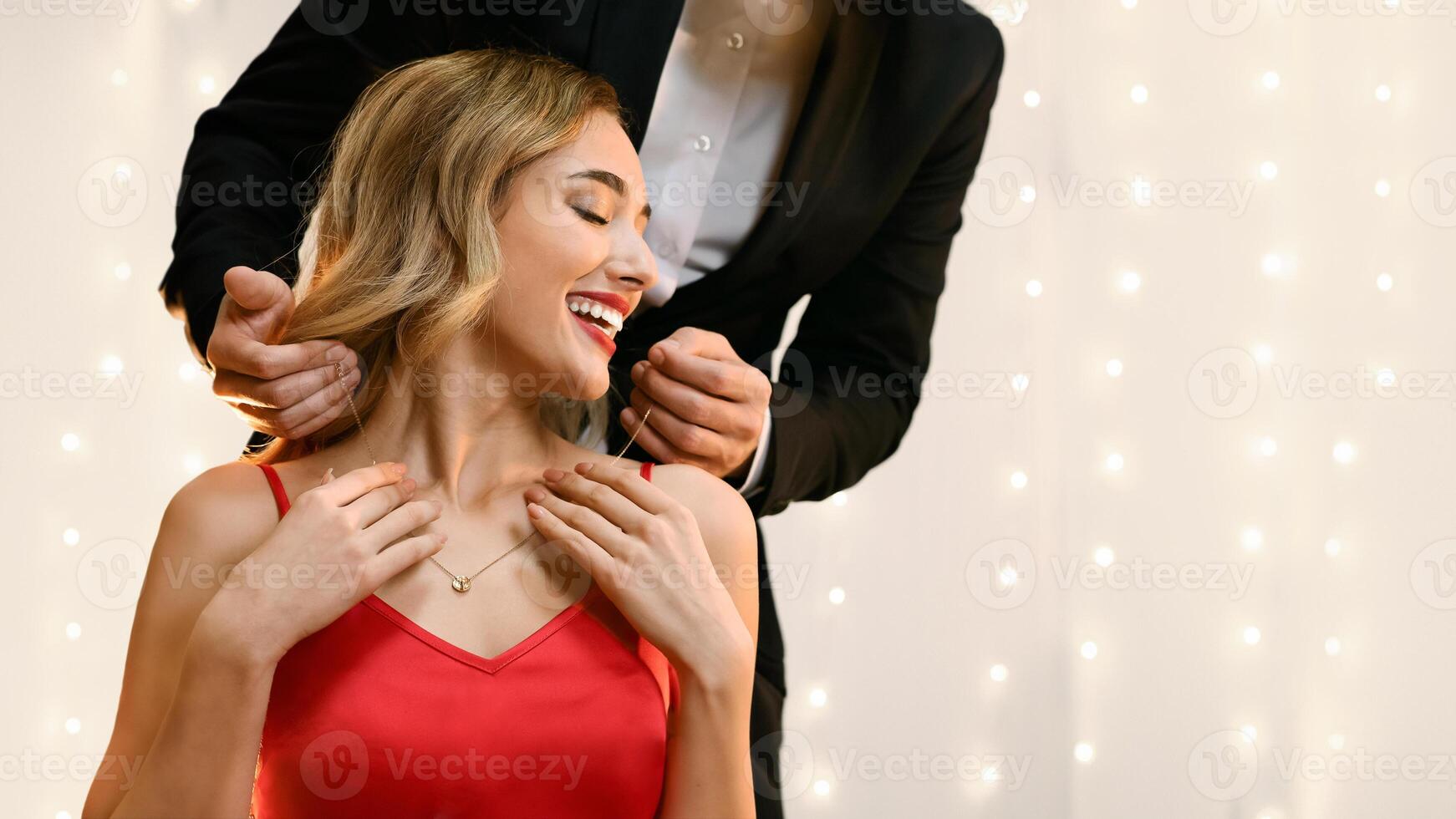 Anniversary Gift. Affectionate Man Presenting Golden Necklace To His Pleased Girlfriend At Romantic Dinner In Restaurant, Copy Space photo