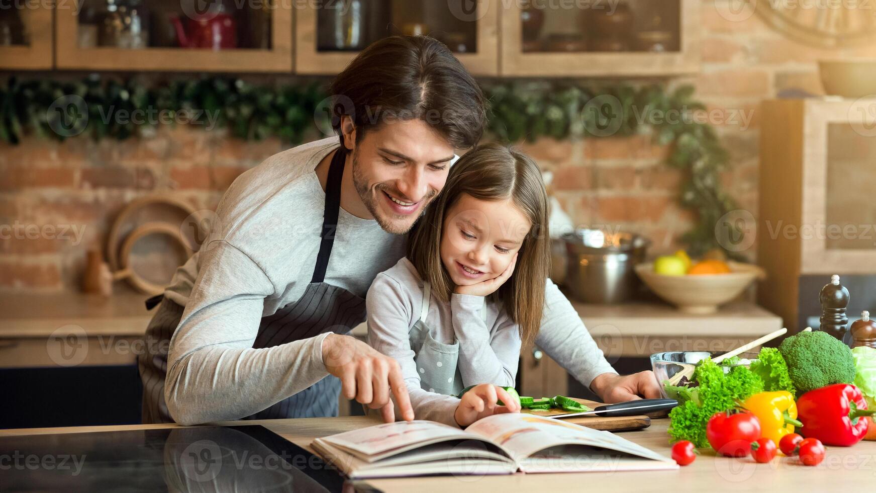 Happy dad and little daughter checking recipe in cookbook at kitchen together while cooking healthy lunch at home, free space photo