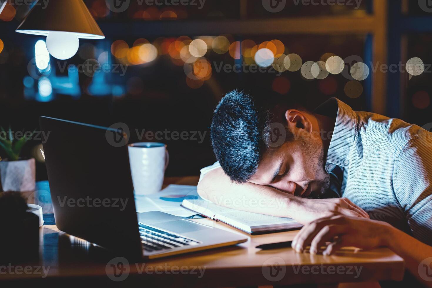 Overworked Manager Sleeping At Laptop Tired After Work In Office At Night. Exhausting Job. Low Light photo