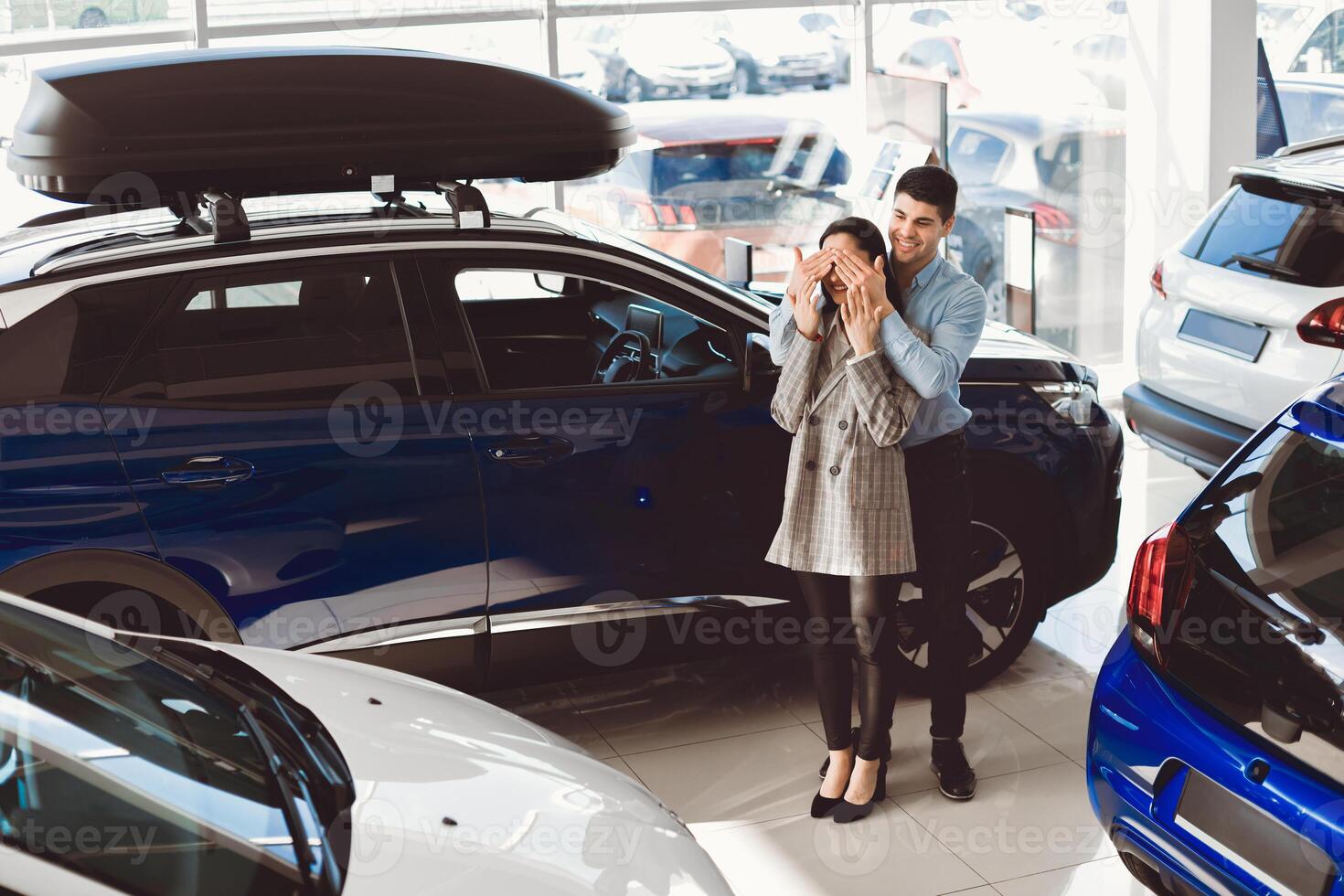 Surprise Concept. Husband Covering Wife's Eyes After Buying Her Brand New Auto In Dealership Store. Empty Space photo